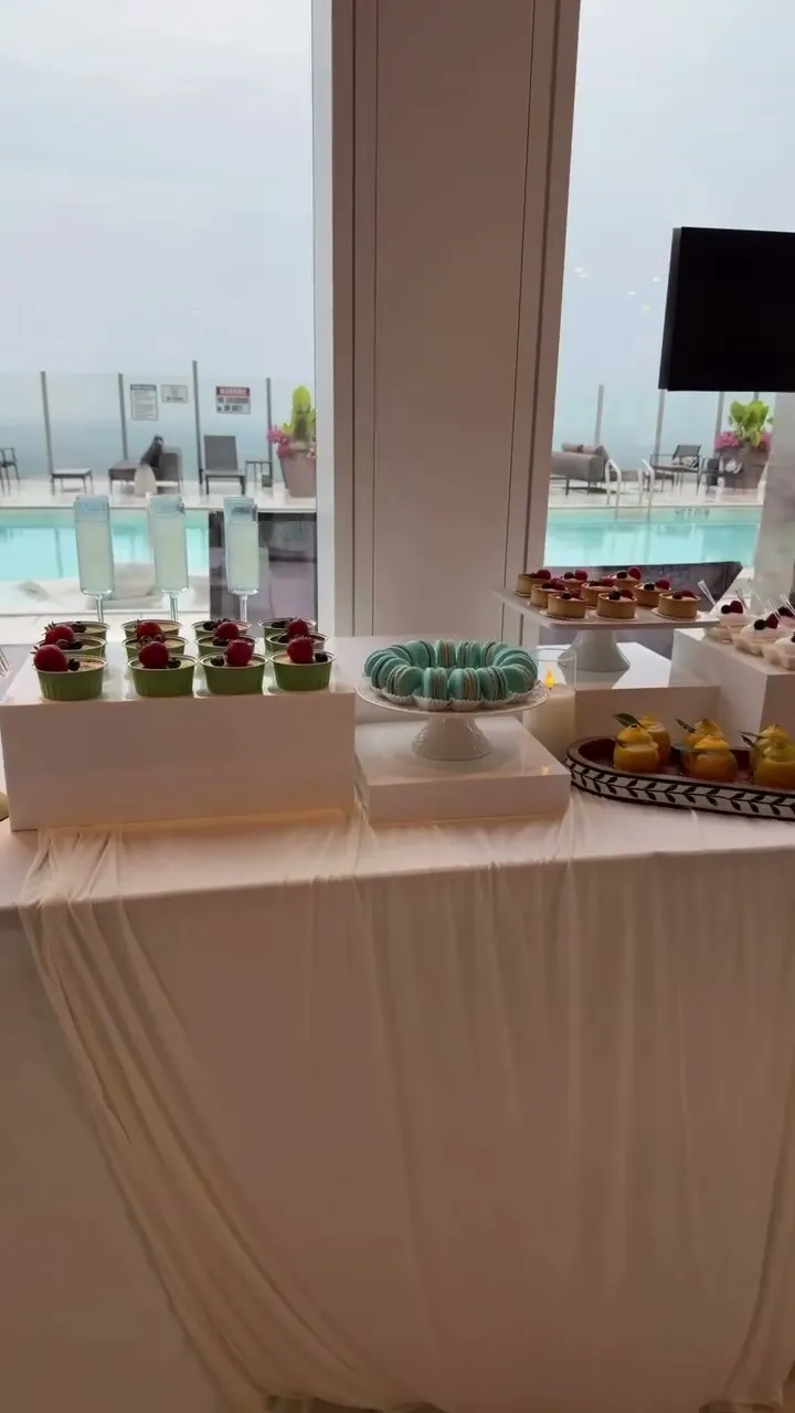 Dessert table at a rooftop pool with blue hydrangea baskets